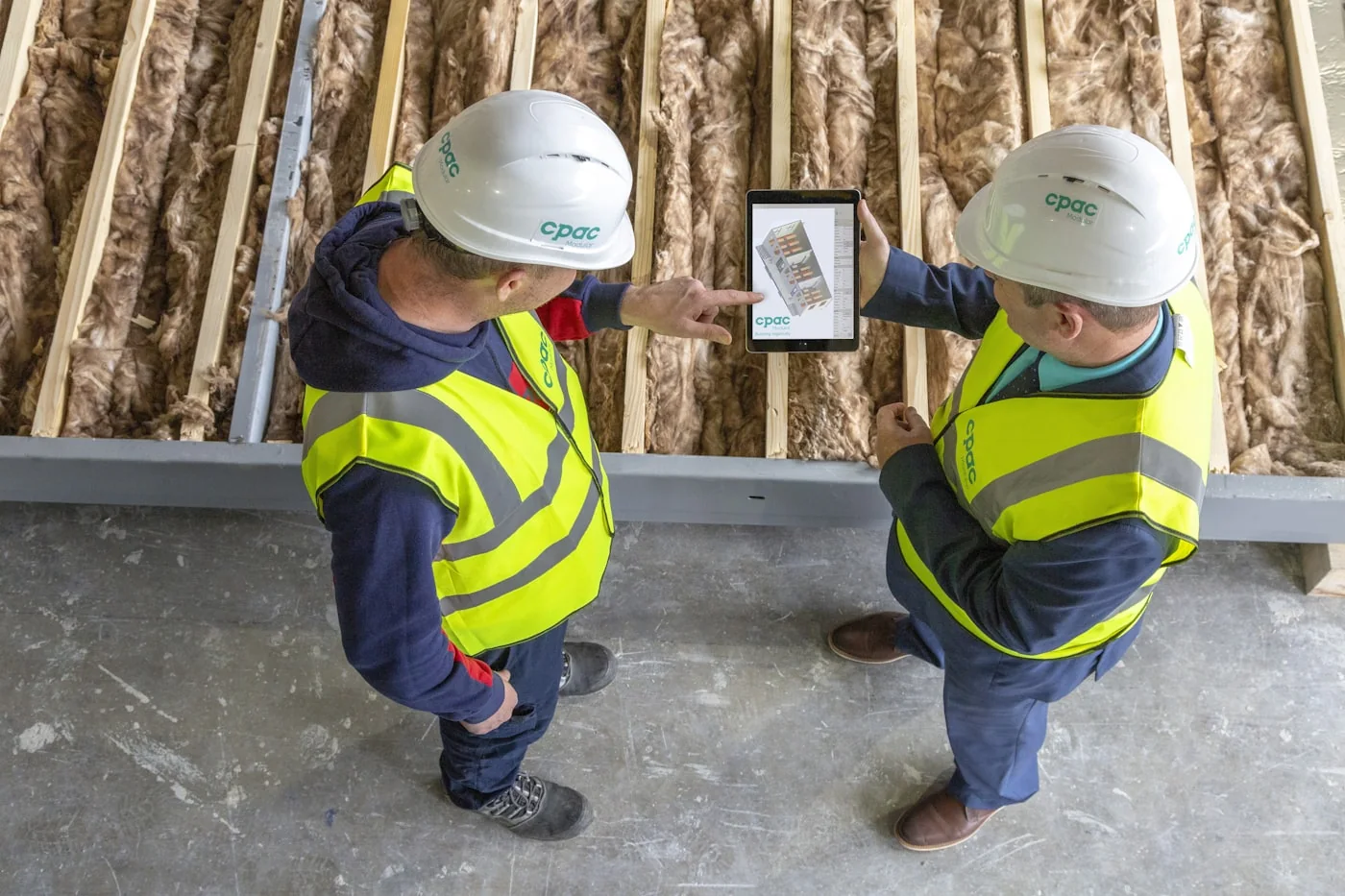 Zwei Profis mit Tablet an der Trockenbauwand